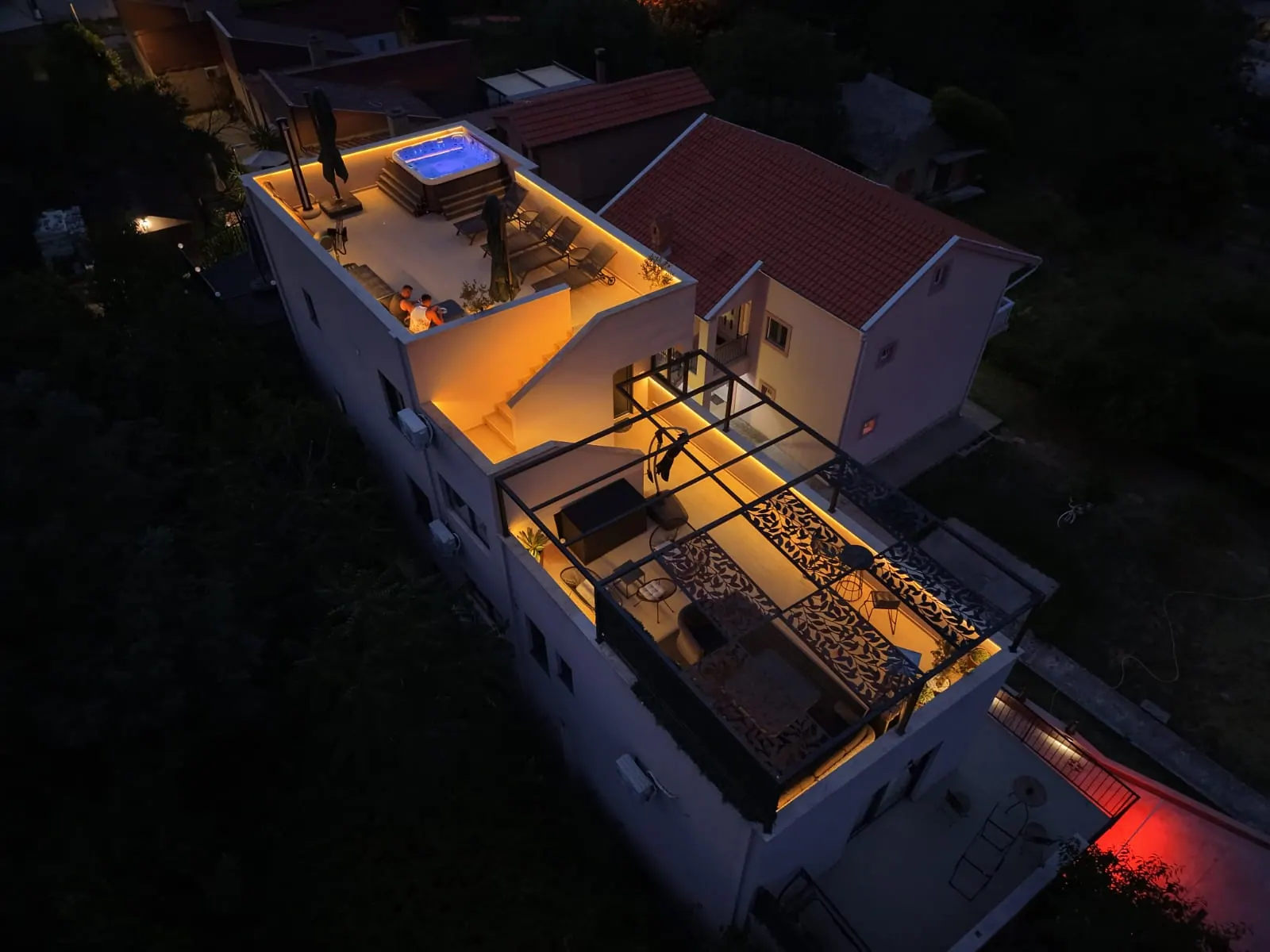 Rooftop terrace and pergola lounge lit up at night